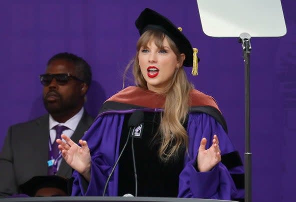 Taylor Swift speaking at a podium during NYU graduation ceremony