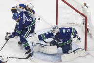 Vancouver Canucks goalie Jacob Markstrom (25) makes a save on St. Louis Blues' Brayden Schenn (10) as Oscar Fantenberg (5) defends during the third period in Game 3 of an NHL hockey first-round playoff series, Sunday, Aug. 16, 2020, in Edmonton, Alberta. (Jason Franson/The Canadian Press via AP)