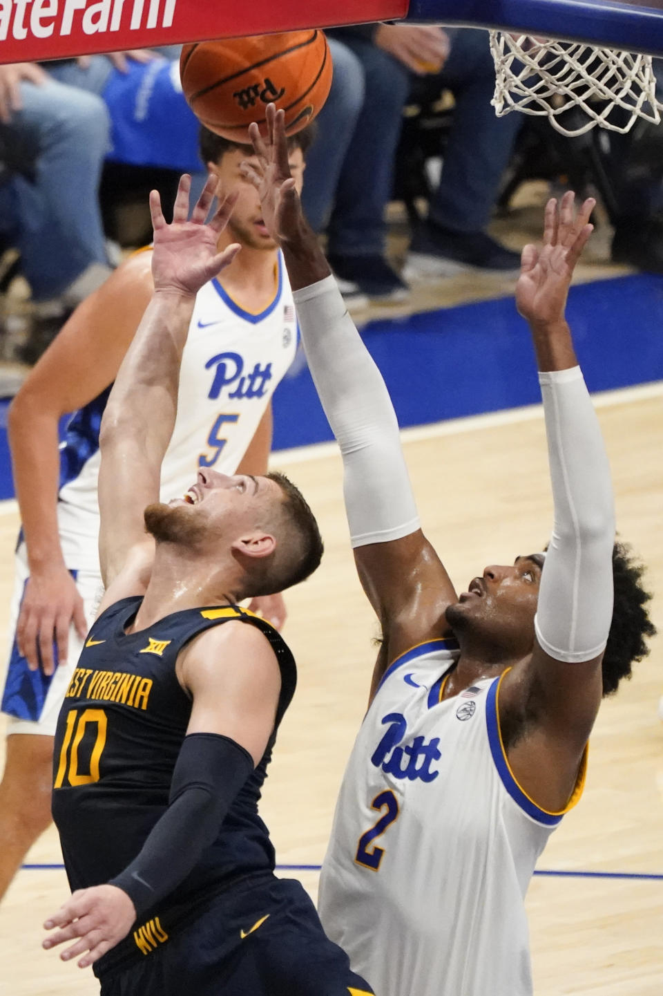 West Virginia's Erik Stevenson (10) scores in front of Pittsburgh's Blake Hinson (2) during the second half of an NCAA college basketball game, Friday, Nov. 11, 2022, in Pittsburgh. (AP Photo/Keith Srakocic)