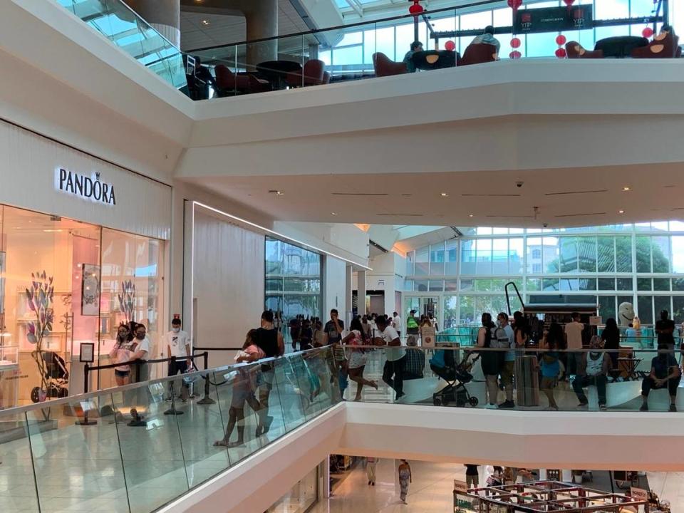 Last minute Mother’s Day shoppers line up outside Pandora, a few shops down from where Saturday’s triple shooting happened.