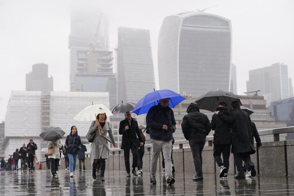 People walk in the rain over London Bridge in central London (PA Wire)