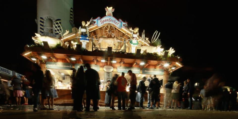 Visitors to the Oktoberfest crowd outside a booth selling roast pork. Schweinebraten (roast pork) and Schweinshaxe (grilled ham hock) are favorite to-go foods with beer.