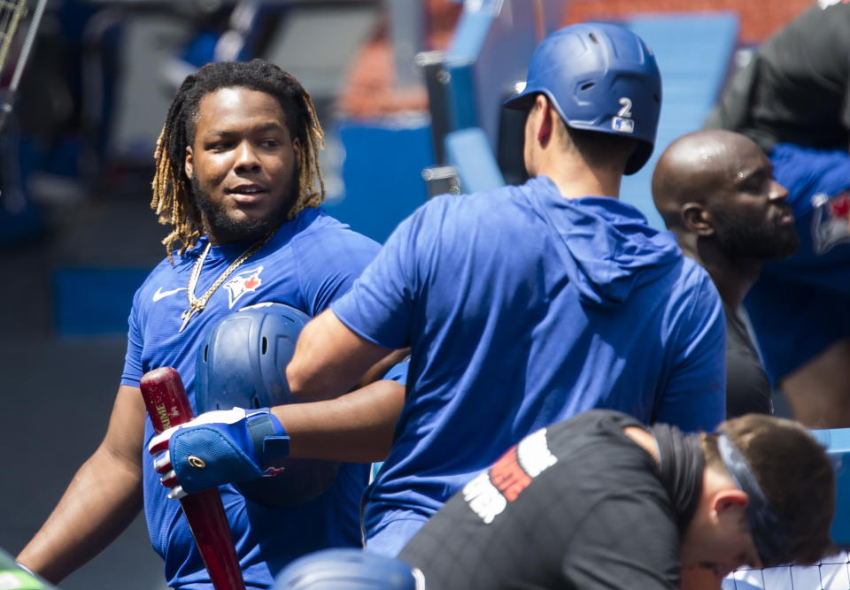 Toronto Blue Jays infielder Vladimir Guerrero Jr., left, talks with teammate Joe Panik (2) during MLB training baseball action in Toronto on Monday, July 20, 2020. (Nathan Denette/The Canadian Press via AP)