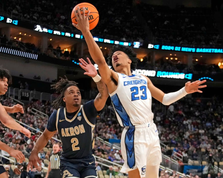 Creighton’s Trey Alexander (23) goes for a lay up against Akron’s Greg Tribble (2) during the first half of a college basketball game in the first round of the NCAA men’s tournament in Pittsburgh, Thursday, March 21, 2024. (AP Photo/Gene J. Puskar)