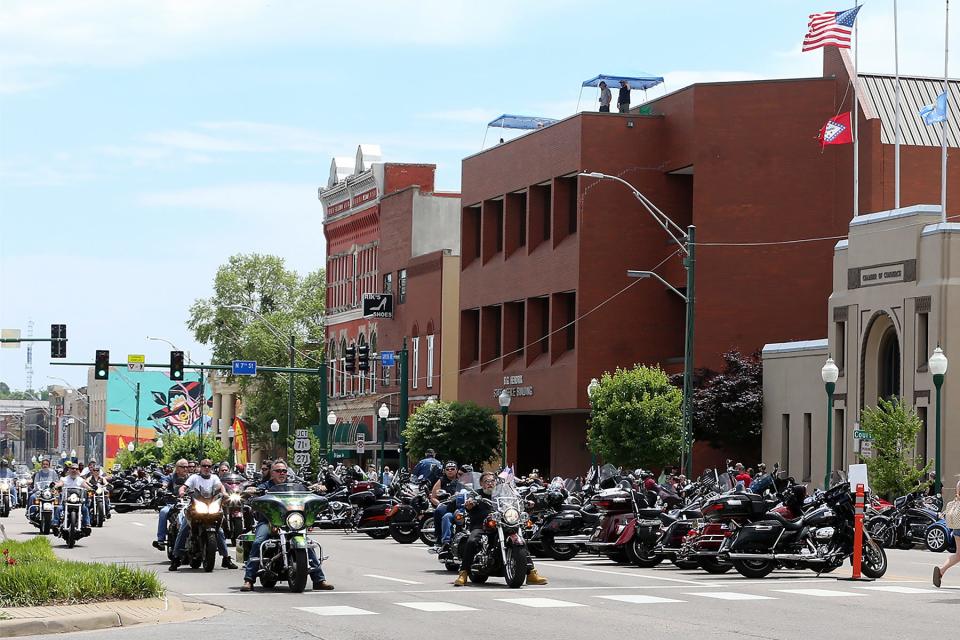 Riders cruise Garrison Ave. around parked motorcycles during the annual Steel Horse Rally in Fort Smith.