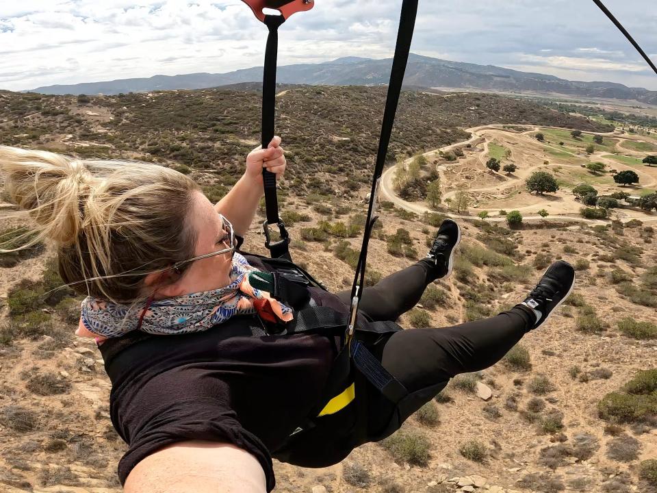 woman ziplinning over san diego zoo animals