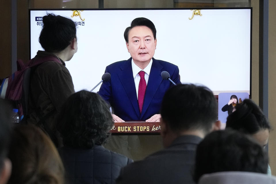 People watch a TV screen showing the live broadcast of South Korean President Yoon Suk Yeol's press conference, at the Seoul Railway Station in Seoul, South Korea, Thursday, May 9, 2024. (AP Photo/Ahn Young-joon)