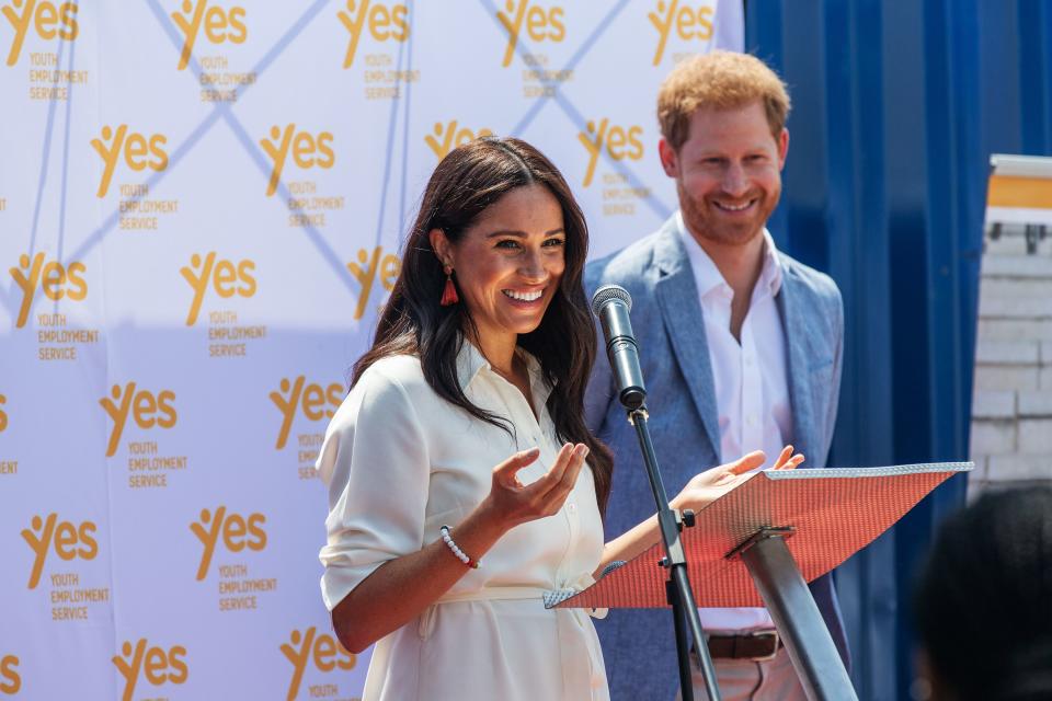 Meghan, Duchess of Sussex(L), is watched by Britain's Prince Harry, Duke of Sussex(R) as  she delivers a speech at the Youth Employment Services Hub in Tembisa township, Johannesburg, on October 2, 2019. - Meghan Markle is suing Britain's Mail On Sunday newspaper over the publication of a private letter, her husband Prince Harry has said, warning they had been forced to take action against "relentless propaganda". (Photo by Michele Spatari / AFP) (Photo by MICHELE SPATARI/AFP via Getty Images)