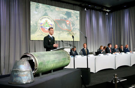 Dutch police officer Wilbert Paulissen, head of the National Crime Squad, is pictured next to a damaged missile as he presents interim results in the ongoing investigation of the 2014 MH17 crash that killed 298 people over eastern Ukraine, during a news conference by members of the Joint Investigation Team, comprising the authorities from Australia, Belgium, Malaysia, the Netherlands and Ukraine, in Bunnik, Netherlands, May 24, 2018. REUTERS/Francois Lenoir