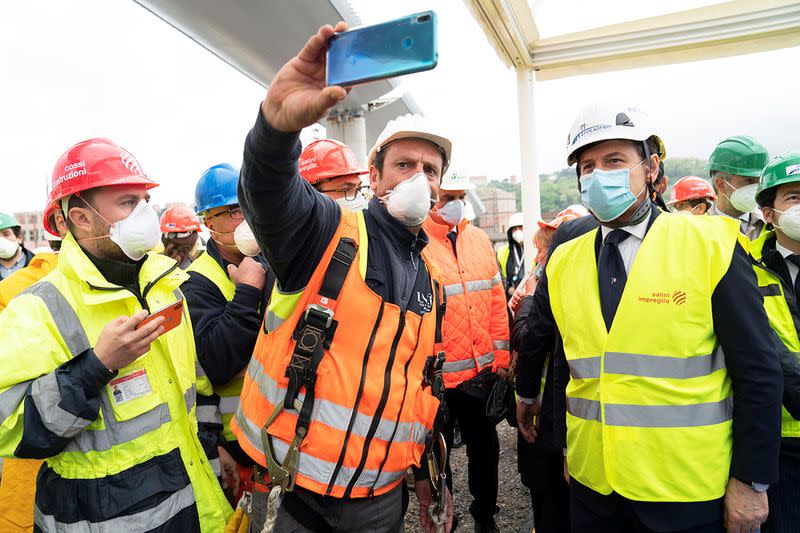 Italian Prime Minister Giuseppe Conte wearing a protective face mask attends the inauguration ceremony of the final section of Genoa's new bridge being installed into place and completing the rebuilding of the structure, in Genoa