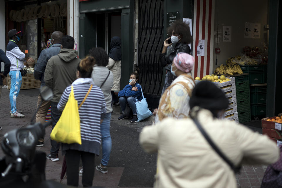 People wait in line at a money exchange shop in Marseille, southern France, Monday, May 11, 2020. France is beginning to reopen Monday after two months of virus confinement measures. Shops, hair salons and some other businesses are reopening Monday and French citizens no longer need a special permission form to leave the house. (AP Photo/Daniel Cole)