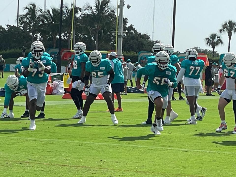 Dolphins offensive linemen Austin Jackson (73) and Connor Williams warm up for practice.