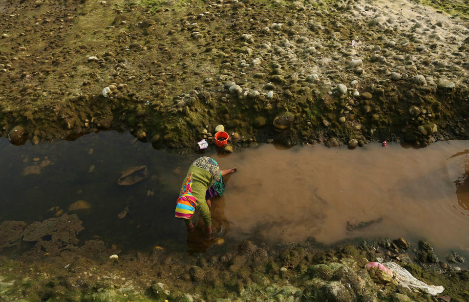 A girl fishes with her bare hands in Jammu, India