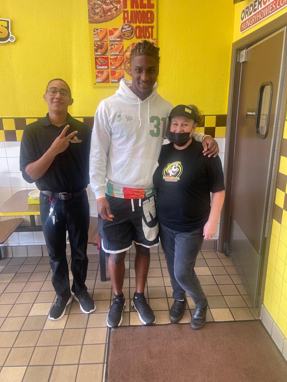 Florida A&M University linebacker Isaiah Land (middle) poses for photo with Hungry Howie’s Pizza general manager David Lopez (left) and employee Debbie Wallace (right) during NIL appearance at Apalachee Parkway location in Tallahassee, Florida, Wednesday, Nov. 2, 2022