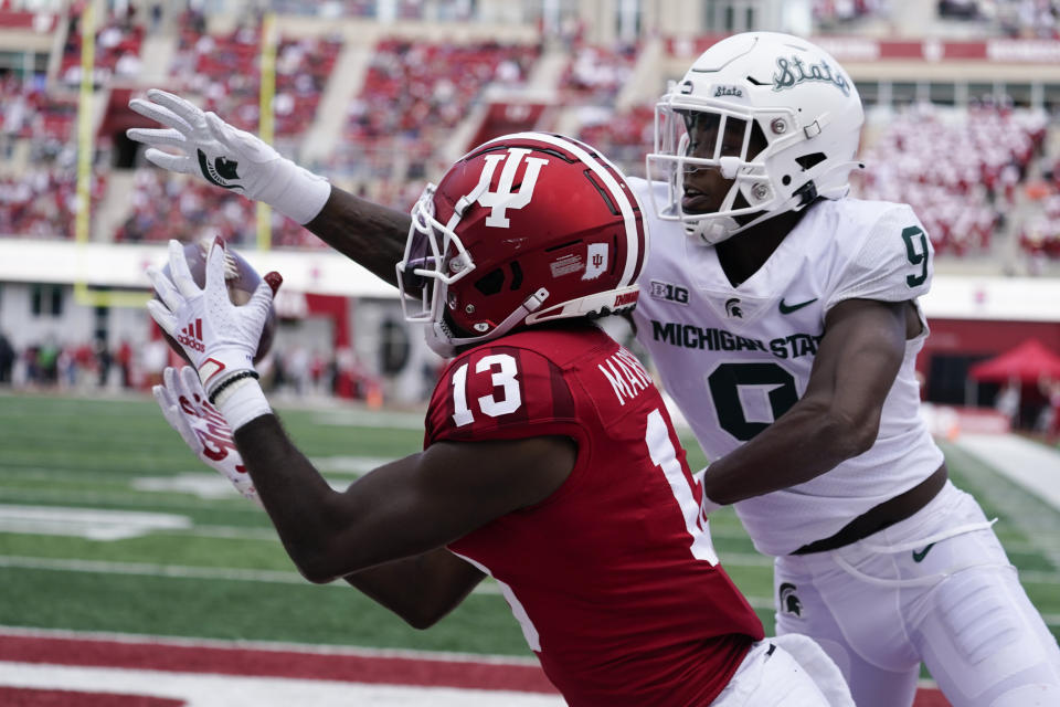 Indiana's Miles Marshall (13) makes a catch against Michigan State's Ronald Williams during the second half of an NCAA college football game, Saturday, Oct. 16, 2021, in Bloomington, Ind. Michigan State won 20-15. Marshall was ruled out-of-bounds on the catch, (AP Photo/Darron Cummings)