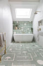 <p> There are several things to love about this bathroom. Firstly, the light! And secondly, we love how the Brasilia floor tiles from Popham Design have continued up the wall, which draws your eye away from the fact that the bathroom is actually super narrow. </p> <p> The beautiful white Victoria + Albert Eldon bath breaks up the pattern, yet the shape of it and the white pattern on the tiles link cleverly. The gold taps, shower, and towel rail add a hint of warmth to the white-painted side walls finishing off the space to a T.&#xA0; </p>