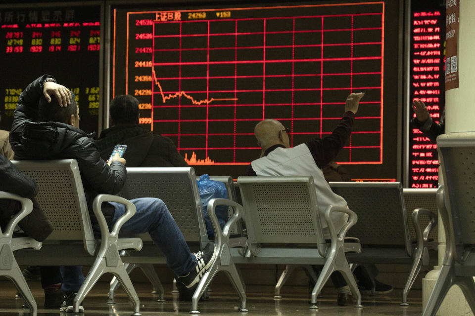 In this Thursday, Dec. 12, 2019, photo, investors monitor stock prices at a brokerage in Beijing. Shares likewise jumped Friday, Dec. 13, 2019 in Asia following fresh all-time highs overnight on Wall Street spurred by optimism that the U.S. and China are close to reaching a deal to end their costly trade war. (AP Photo/Ng Han Guan)