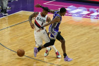 Portland Trail Blazers guard Damian Lillard, left, dodges Sacramento Kings guard De'Aaron Fox, right, during the second quarter of an NBA basketball game in Sacramento, Calif., Wednesday, Jan. 13, 2021. (AP Photo/Rich Pedroncelli)