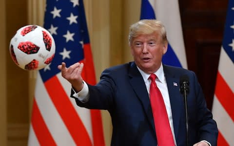 The US president tossed the ball to his wife, Melania, sitting in the front row - Credit: AFP