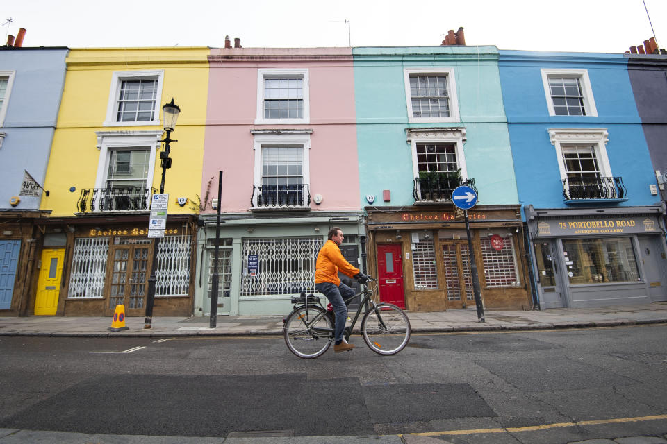 A cyclist rides past closed up shops on Portobello Road in West London as the UK continues in lockdown to help curb the spread of the coronavirus.