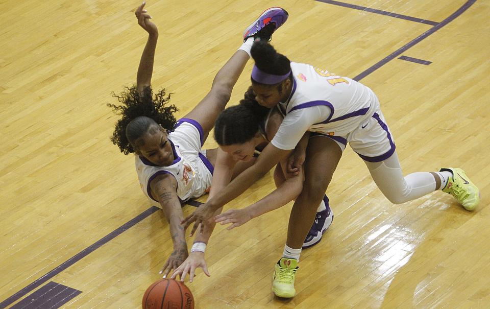 Reynoldsburg's Daniya McDonald, left, and Malaya Collins, battle Pickerington Central's Berry Wallace for the ball during their game Nov. 29.