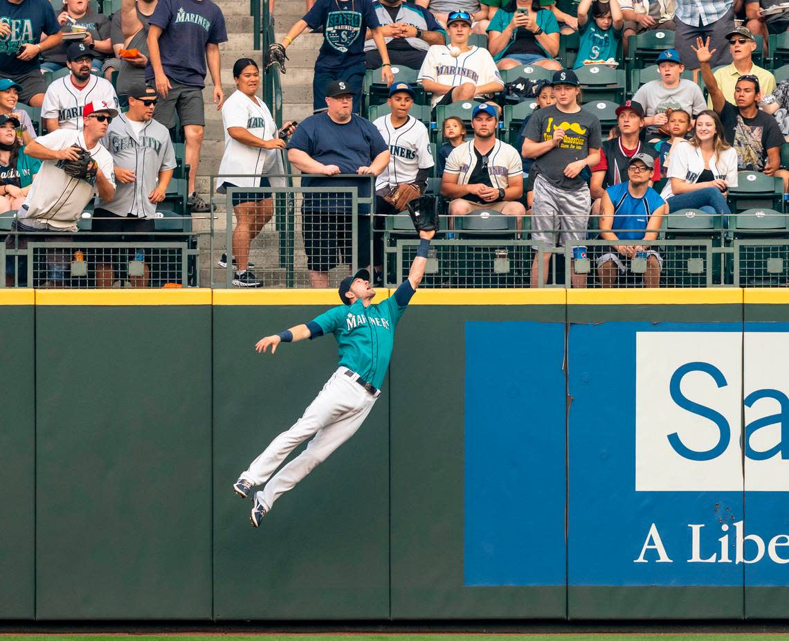 Rightfielder Mitch Haniger (17) of the Seattle Mariners jumps to make a catch for an out on a ball hit by Vladimir Guerrero (27) of the Toronto Blue Jays during the first inning of a game at T-Mobile Park on Aug. 13, 2021 in Seattle. The Mariners edged the Blue Jays, 3-2.