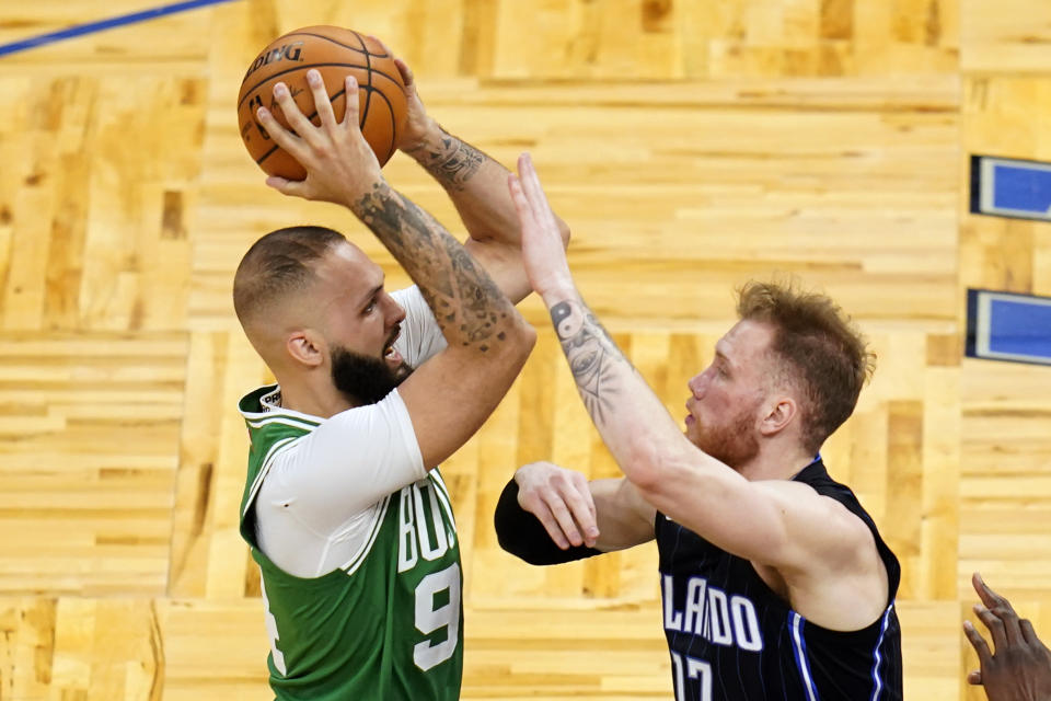 Boston Celtics guard Evan Fournier, left, goes up for a shot against Orlando Magic forward Ignas Brazdeikis during the second half of an NBA basketball game, Wednesday, May 5, 2021, in Orlando, Fla. (AP Photo/John Raoux)