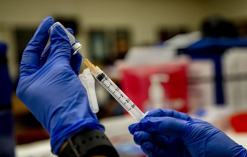 RIVERSIDE, CA - SEPTEMBER 22, 2021: A nurse prepares a syringe with the J & J vaccine in the library of Arlington High School on September 22, 2021 in Riverside, California. A Los Angeles Times analysis has found counties in the Inland Empire had a higher rate of hospitalizations this summer than any other county in Southern California.(Gina Ferazzi / Los Angeles Times)