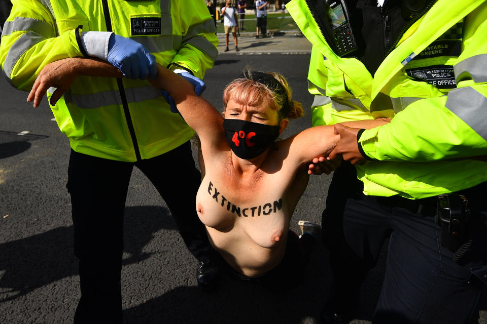 NOTE NUDITY Police detain a topless Extinction Rebellion protester outside the Houses of Parliament, London, on the last day of demonstrations.