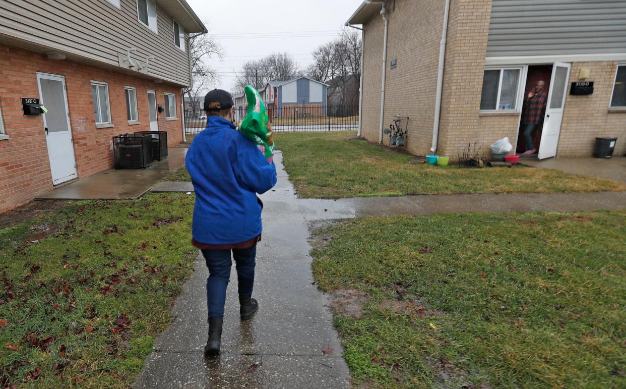 Meals & More Driver Lynda Greig takes a bag of dog food to Sarita Williams's home Thursday, Feb. 17, 2022 in Indianapolis. As part of the Meals & More service, CICOA Aging & In-Home Solutions launched the Pet Connect pilot program, in Feb. 2022, offering pet food and supplies to low-income, homebound seniors. A study by University of Michigan and AARP found that pets help seniors relieve stress and provide a sense of purpose. CICOA, with a grant from Wheels on Meals America, can help at least 100 clients this year.