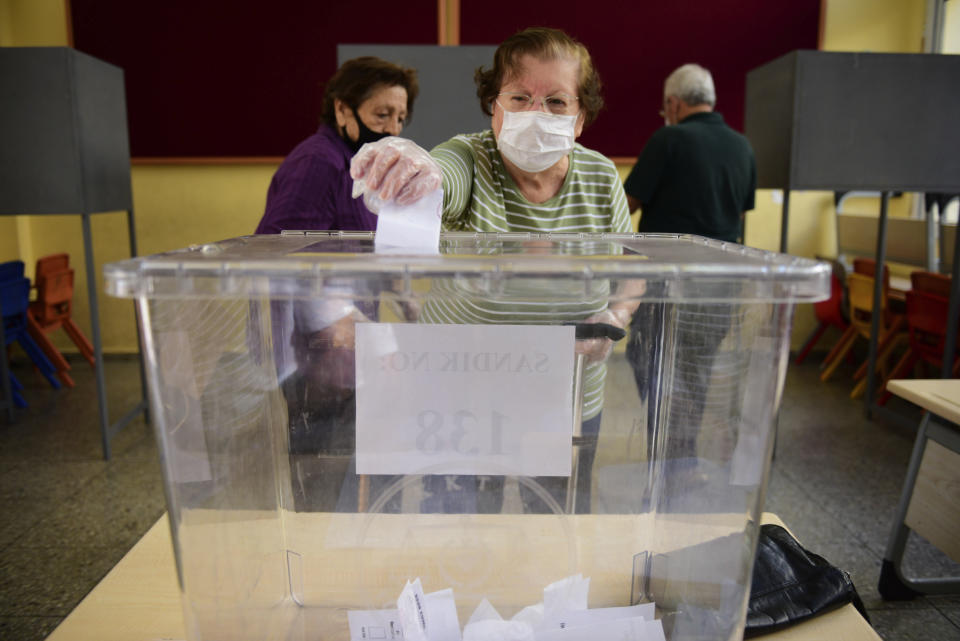 A woman casts her ballot at a polling station during Turkish Cypriots election for a new leader in the Turkish occupied area in the north part of the divided capital Nicosia, Cyprus, Sunday, Oct. 18, 2020. Turkish Cypriots began voting Sunday in a leadership runoff to choose between an incumbent who pledges a course less bound by Turkey’s dictates and a challenger who favors even closer ties to Ankara. (AP Photo/Nedim Enginsoy)