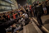 Police clash with protesters during a demonstration at El Prat airport, outskirts of Barcelona, Spain, Monday, Oct. 14, 2019. Spain's Supreme Court on Monday sentenced 12 prominent former Catalan politicians and activists to lengthly prison terms for their roles in a 2017 bid to gain Catalonia's independence, sparking protests across the wealthy Spanish region. (AP Photo/Bernat Armangue)