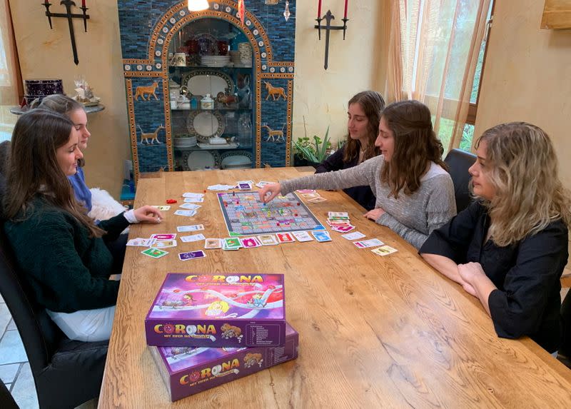 Rebecca, Lara, Stella y Sarah Schwaderlapp juegan 'Corona - el juego de mesa de la carrera hacia las tiendas' inventado por Lara y Sarah para pasar el tiempo encerrados, en Wiesbaden Biebrich, Alemania