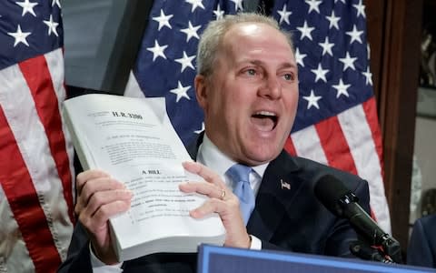 House Majority Whip Steve Scalise, R-La., joined at right Rep. Phil Roe, R-Tenn., holds up a copy of the original Affordable Care Act bill - Credit: AP Photo/J. Scott Applewhite