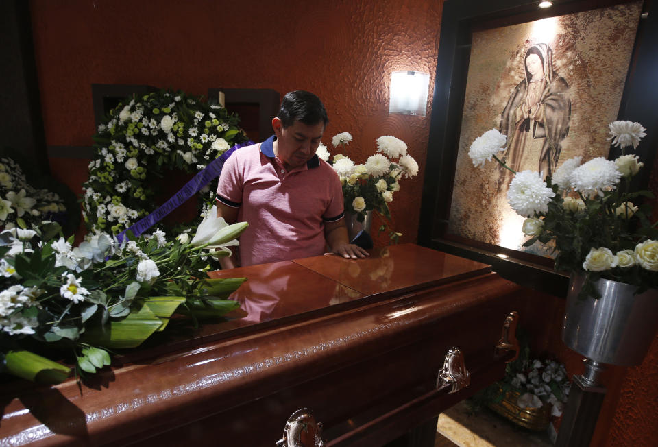 Jesus Sanchez places his hand on the casket containing the remains of his wife Liliana Lopez, 37, who died in the Mexico City Metro collapse disaster, during a wake in Mexico City, Wednesday, May 5, 2021. Monday night’s accident was one of the deadliest in the history of the capital's subway system. (AP Photo/Marco Ugarte)