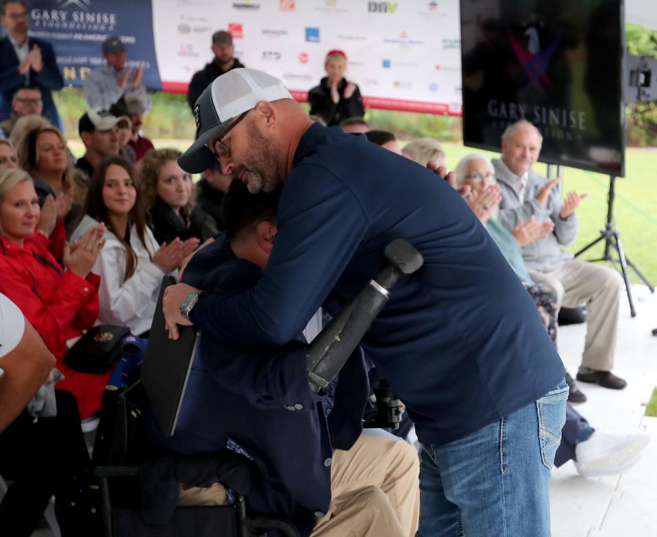 Contractor Michael Roberts hugs Retired U.S. Army Sgt. 1st Class Ryan Davis during a dedication ceremony for the new custom SMART home he helped to build for Davis and his family with the support of the Gary Sinise Foundation.