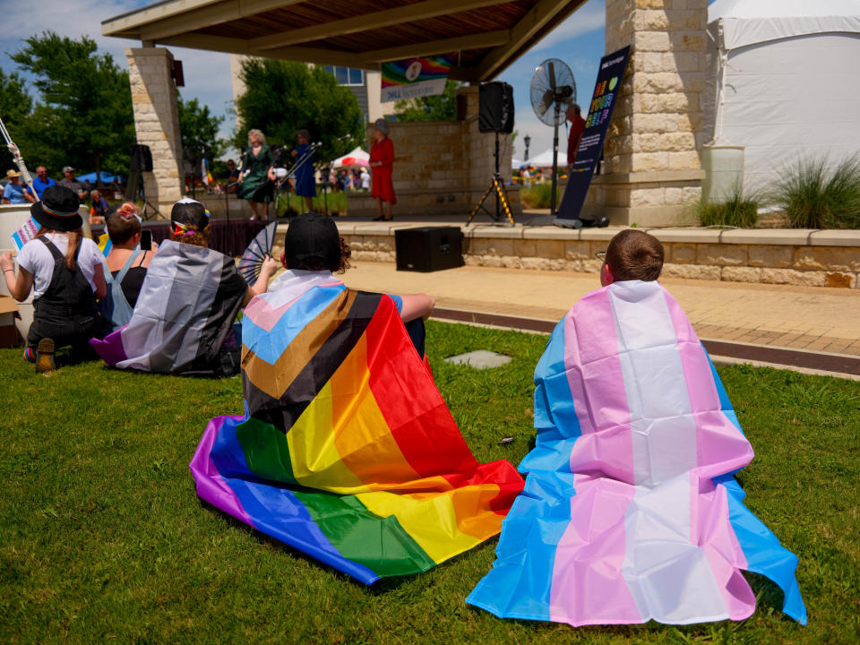 Spectators wear the progress and transgender pride flags while watching performances at the inaugural Round Rock Pride Festival on Saturday.