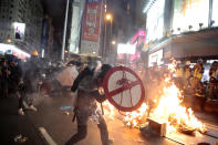 FILE - In this Aug. 31, 2019, file photo, a protester uses a shield to cover himself as he faces police in Hong Kong. Protesters and police are standing off in Hong Kong on a street that runs through the bustling Causeway Bay shopping district. Many in Hong Kong took to the streets in 2019 hoping to salvage rights of free speech and association denied to residents of mainland China, where public dissent is treated as subversive and punishable by long prison terms. (AP Photo/Jae C. Hong, File)