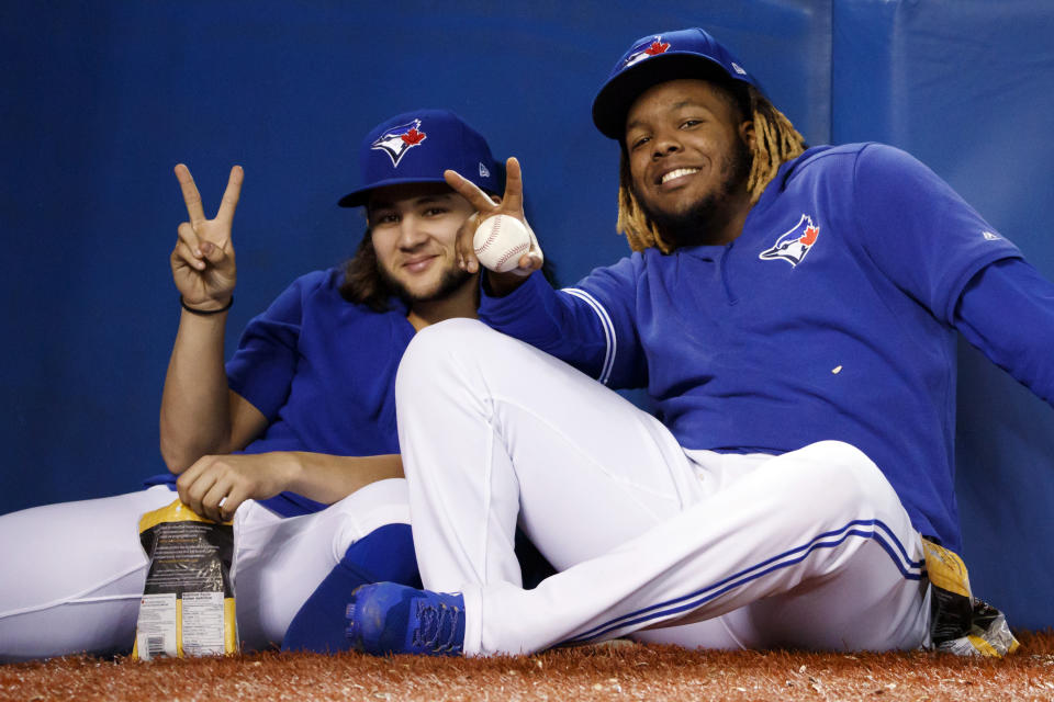 TORONTO, ON - SEPTEMBER 28: Bo Bichette #11 and Vladimir Guerrero Jr. #27 of the Toronto Blue Jays sit in the dugout during the ninth inning of their MLB game against the Tampa Bay Rays at Rogers Centre on September 28, 2019 in Toronto, Canada. (Photo by Cole Burston/Getty Images)