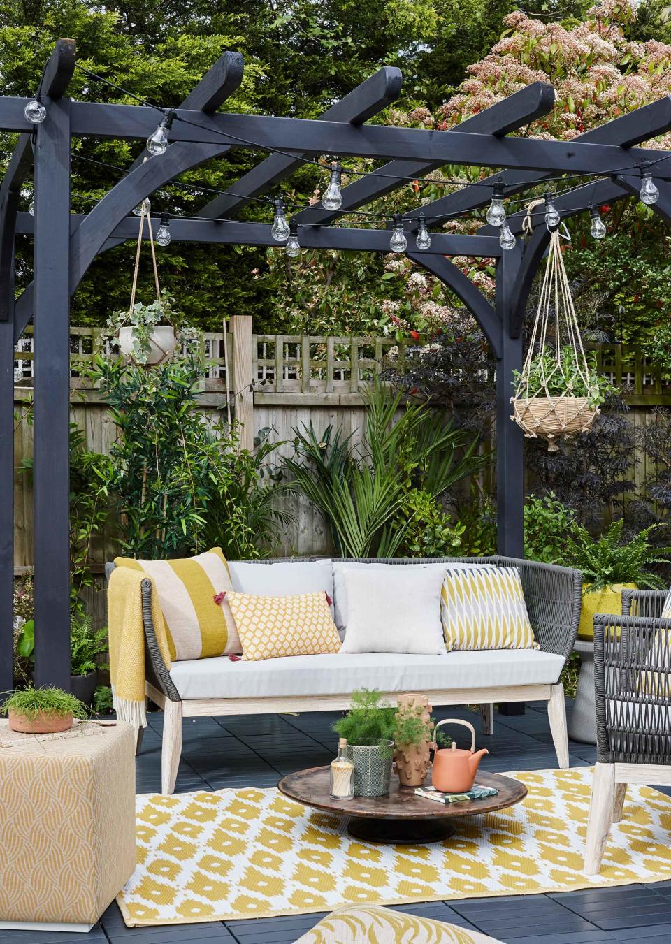 <p> If your garden lacks shelter, then adding a structure like a pergola could be a good option for creating a cozy and welcoming seating area. Painting it a dark color can help it to tie in with your furniture and creates a more fresh and contemporary feel.&#xA0; </p> <p> String&#xA0;festoon lights&#xA0;up for when the sun goes down and frame the area with an outdoor rug and matching cushions to add to the homely style. </p>