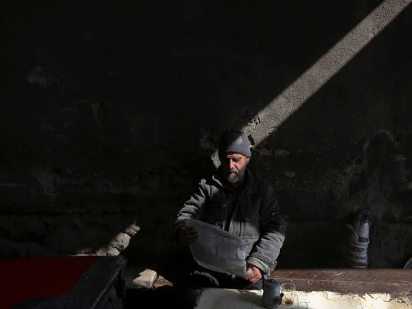 An Afghan man reading a newspaper (Photo Credit - Reuters)