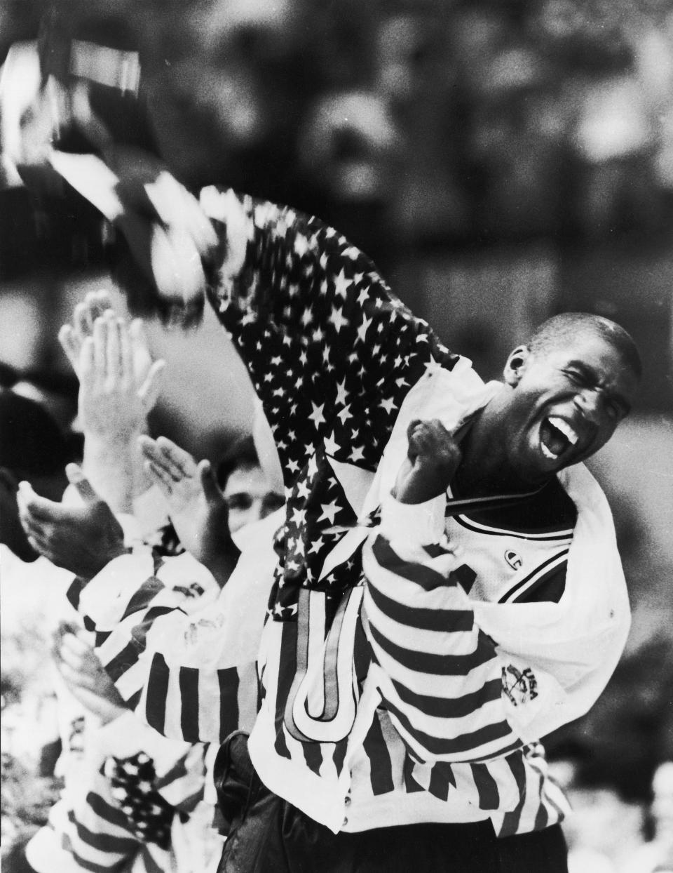 HOLD FOR OBIT-FILE - In this Aug. 8, 1992 photo taken by Associated Press photographer Leonard Ignelzi shows U.S. basketball player Earvin Magic Johnson screams as he lifts the American flag just after receiving his gold medal in Barcelona, Spain. Ignelzi, whose knack for being in the right place at the right time produced breathtaking images of Hall of Fame sports figures, life along the U.S.-Mexico border, devastating wildfires and numerous other major news events over nearly four decades as a photographer for The Associated Press in San Diego, has died. He was 74. (AP Photo/Lenny Ignelzi)