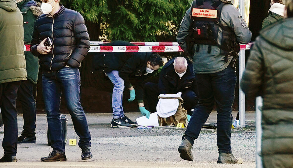 Police officers secure traces on the grounds of the Heidelberg University Botanical Garden in Heidelberg, Germany, Monday, Jan. 24, 2022. German police say a lone gunman wounded several people at a lecture theatre in the southwest city of Heidelberg on Monday. Police said in a brief statement that the perpetrator was dead but didn’t give details of how that happened. (Uwe Anspach/dpa via AP)