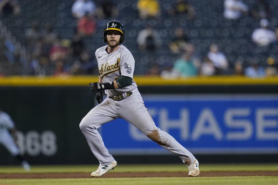 Oakland Athletics' Jed Lowrie runs to third base against the Arizona Diamondbacks during the third inning of a baseball game Tuesday, April 13, 2021, in Phoenix. (AP Photo/Ross D. Franklin)