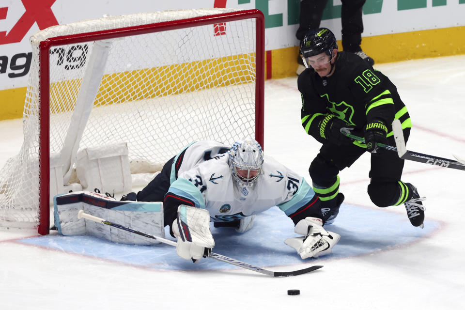 Seattle Kraken goaltender Philipp Grubauer (31) dives for the puck as Dallas Stars center Sam Steel (18) skates in during the third period in an NHL hockey game on Saturday, April 13, 2024, in Dallas. (AP Photo/Richard W. Rodriguez)