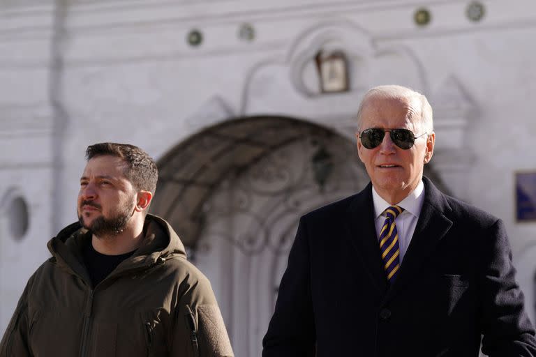 El presidente estadounidense Joe Biden (dcha.) camina junto al presidente ucraniano Volodymyr Zelensky (izq.) a su llegada para una visita en Kiev el 20 de febrero de 2023. (Foto de Dimitar DILKOFF / AFP)