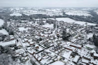 An aerial view of snow covered houses in the village of Oulton in Staffordshire, England, Monday, Dec. 28, 2020. In the aftermath of Storm Bella swathes of the UK are braced for a cold snap, with snow and ice warnings in force across the country. (Tom Leese/PA via AP)