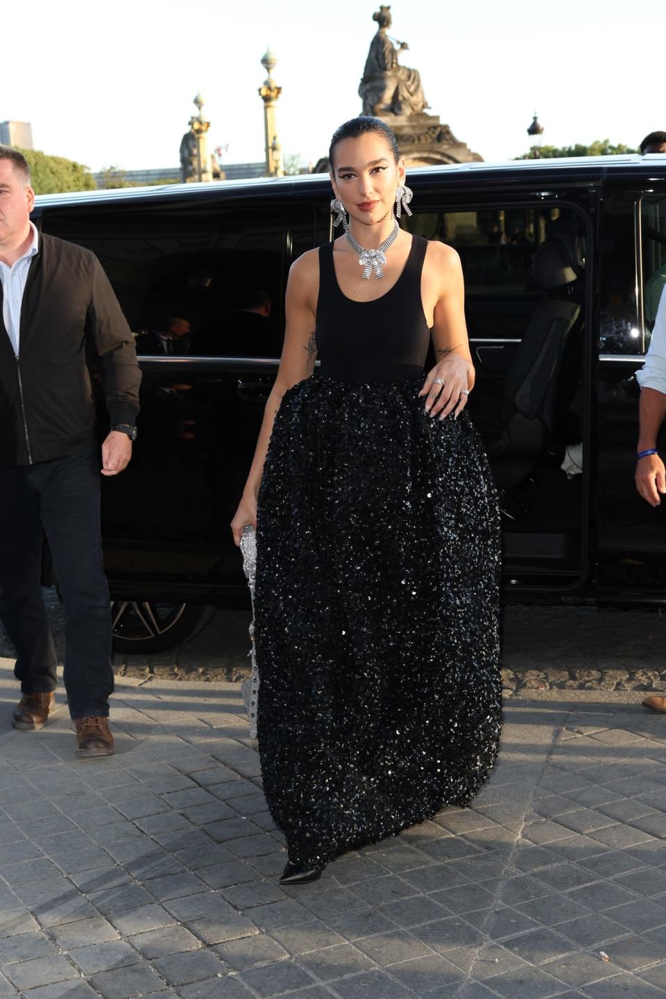 <p>Captamos a la cantante llegando al desfile de moda de Balenciaga, en París, con este fabuloso traje negro de la misma marca. </p>