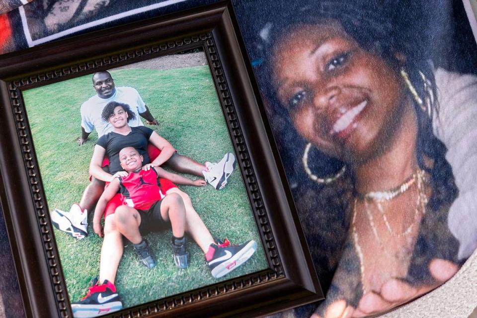 A framed photograph of Atari Thomas, his daughter, Hannah Esquilin, and son, Braylon sits atop a blanket featuring a photograph of his wife, Tiffany. Thomas had the blanket made for Tiffany to mark their seven-year anniversary in 2020. Tiffany was eight months pregnant when she died in 2021.