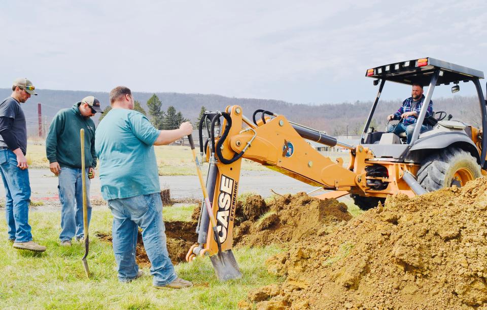 At Ritchie, everyone pitches in. Jeremy Churnesky, Matt Lewis and Hayden Spalding stand by as Ritchie owner/developer John Krumpotich operates a backhoe in early April.